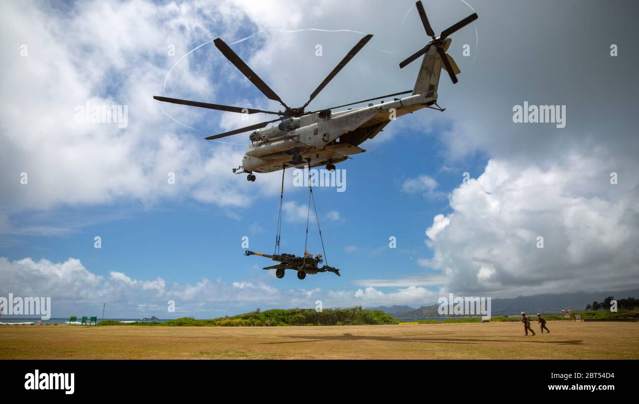 U.S. Marine Corps CH-53E Super Stallion helicopter with Marine Heavy Helicopter Squadron 463 lifts the M777 Howitzer during a hoist lift exercise on Marine Corps Base Hawaii, May 21, 2020. HMH-463 worked with 1st Battalion, 12th Marines and Combat Logistics Battalion 3 to increase proficiency and combat readiness.  (U.S. Marine Corps photo by Cpl. Eric Tso) Stock Photo