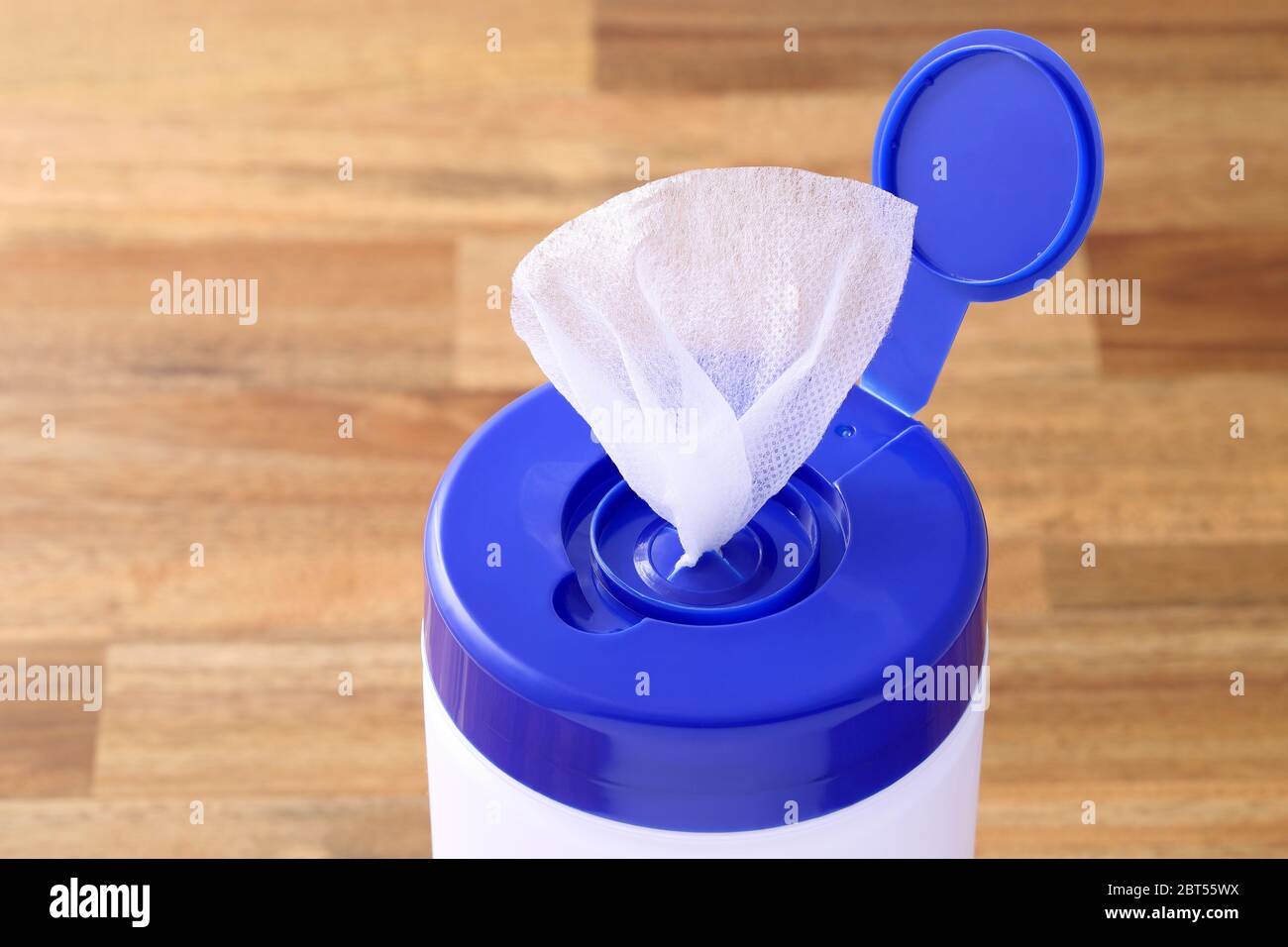 plastic tube shaped box of wet tissue paper on wooden table Stock Photo