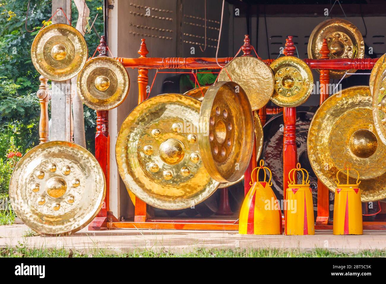 Gongs hanging outside a workshop and shop in Ubon Ratchathani, Thailand Stock Photo