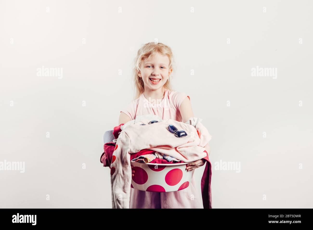Mommy little helper. Smiling Caucasian girl child holding washbasin