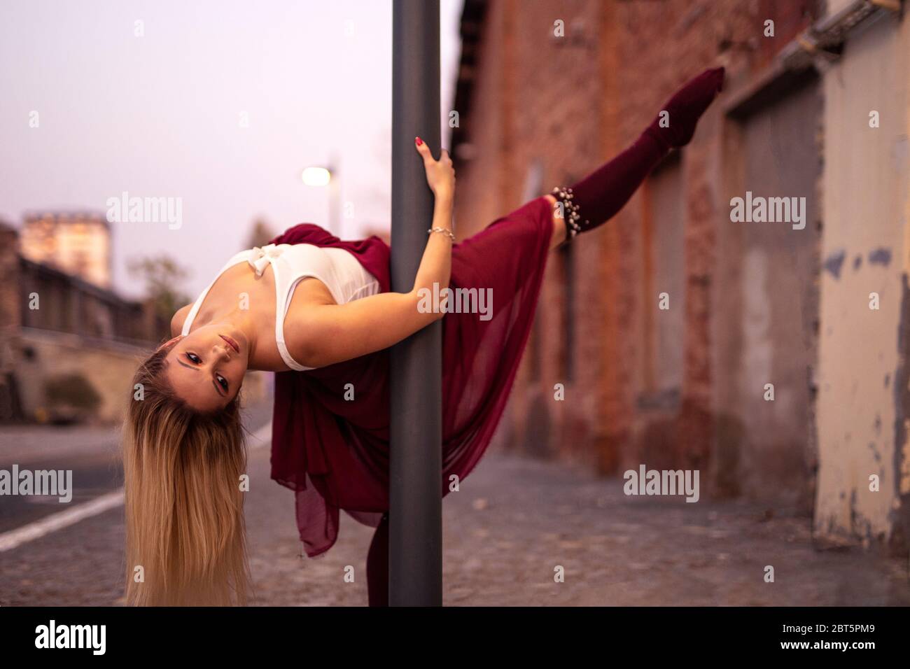 Beautriful athletic woman in body on street lamppost Stock Photo