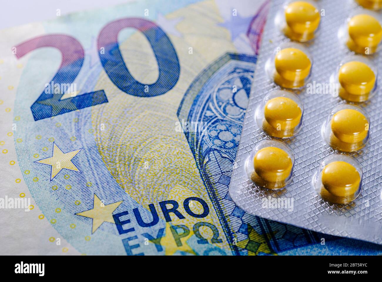 Sealed blister pack of pills on a 20 Euro note in a concept of the coast of treatment, medicine or healthcare in a full frame close up Stock Photo