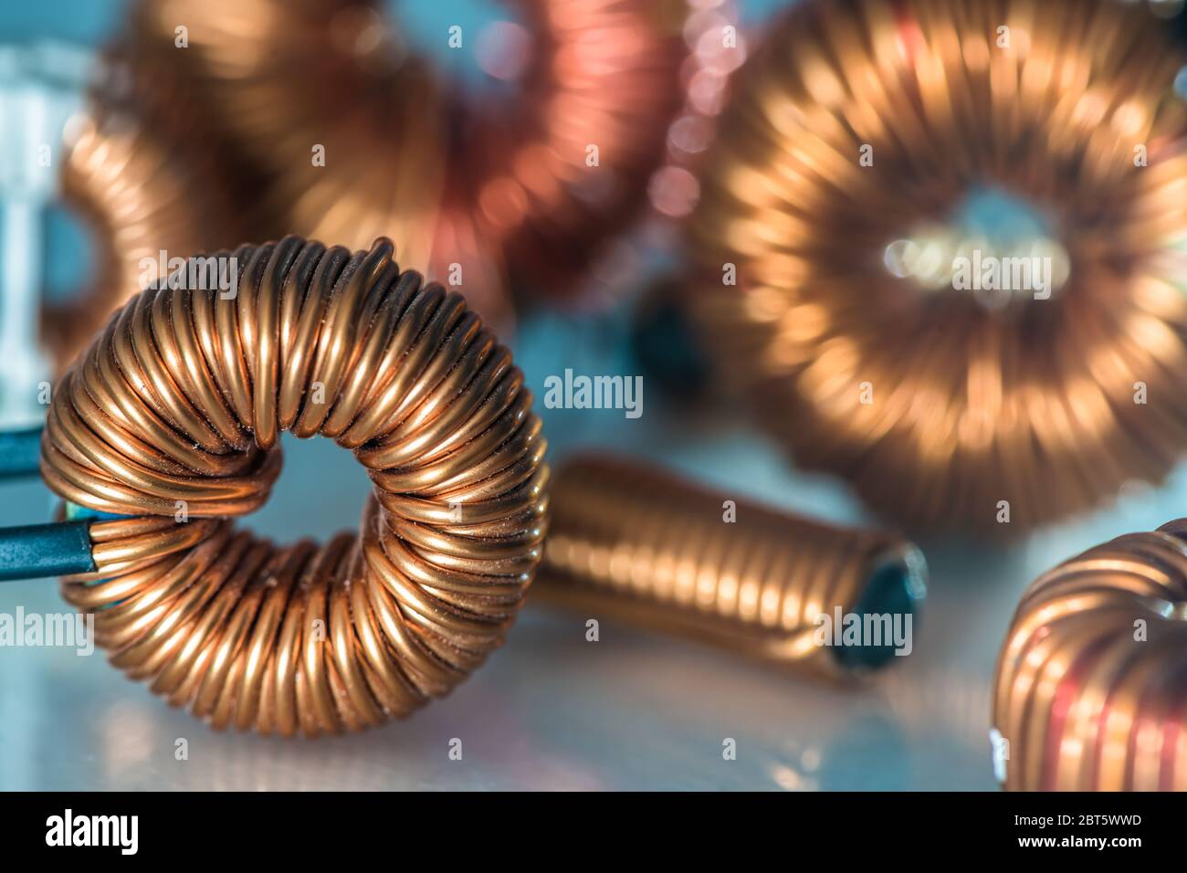 Copper coil and parts of electrical installation with blurred background Stock Photo