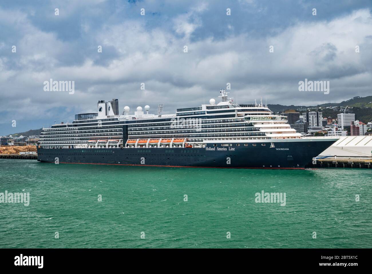 MS Noordam, Holland America Line cruise ship, moored moored under dark clouds at Aotea Quay in Wellington, North Island, New Zealand Stock Photo