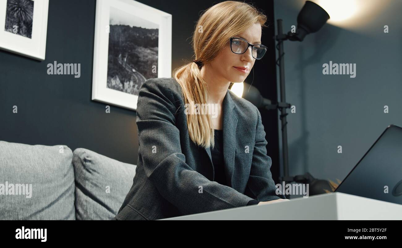 Businesslady working laptop on sofa Stock Photo