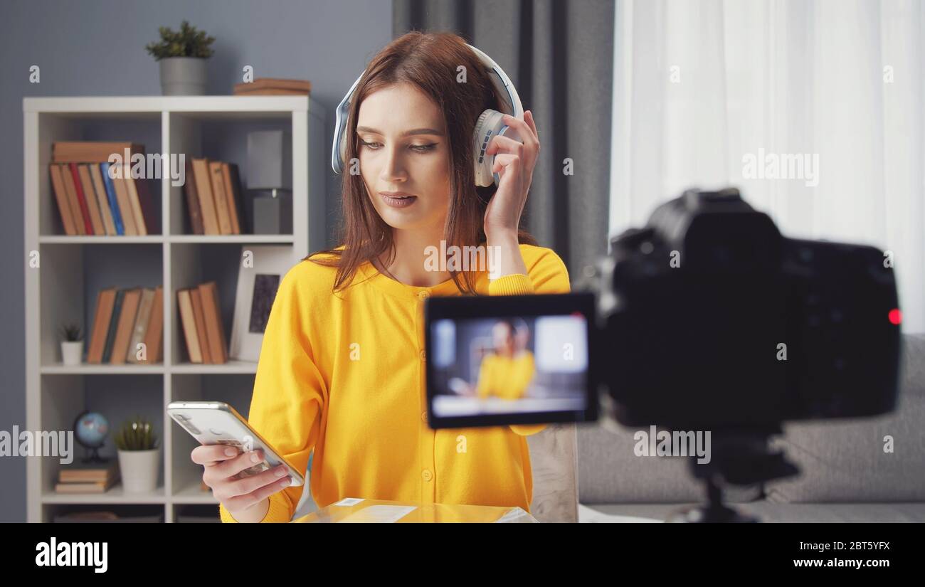 Female vlogger testing wireless headphones Stock Photo