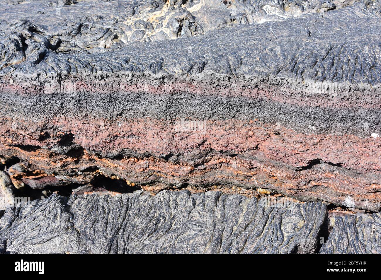 Crack in igneous rock dry lava colorful minerals Stock Photo