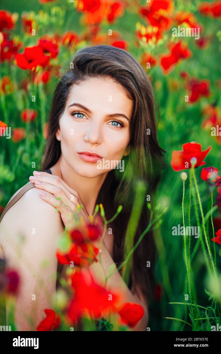 Beautiful young girl in poppy fields at sunset Stock Photo - Alamy