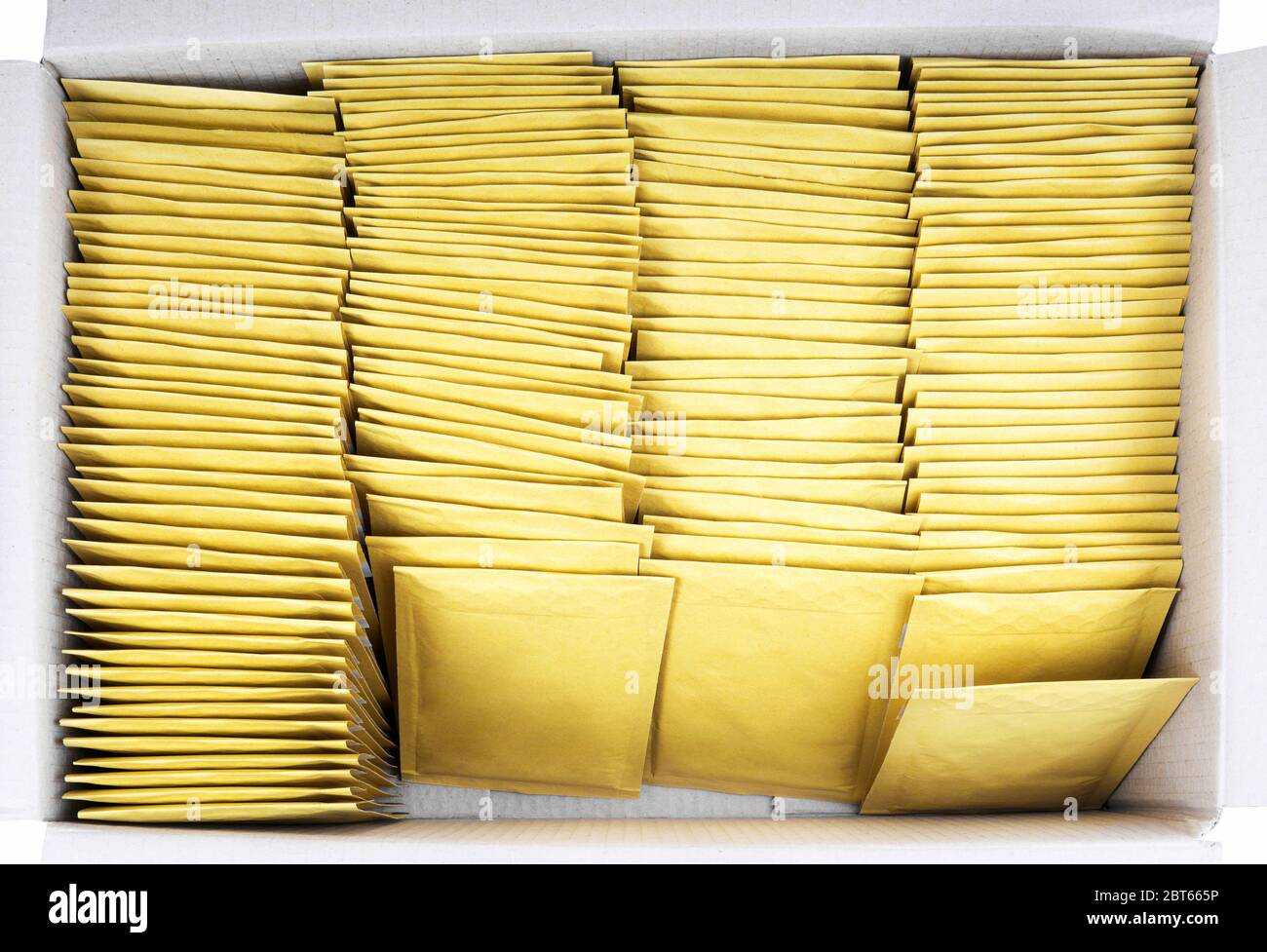Lot of yellow paper postal envelopes in a shipping cardboard box. Top