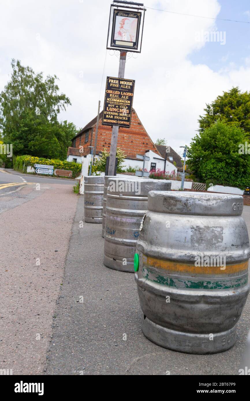 Ashford, Kent, UK. 23rd May, 2020. Friends and neighbours in the village of Hamstreet near Ashford in Kent occupy their time with chores about the house. The local village pub, The Kings Head has been closed now for 2 months, it will remain closed until the 3rd step in the governments guidelines to reopen business. Empty beer barrels sit in front of the entrance to the pub. ©Paul Lawrenson 2020, Photo Credit: Paul Lawrenson/Alamy Live News Stock Photo