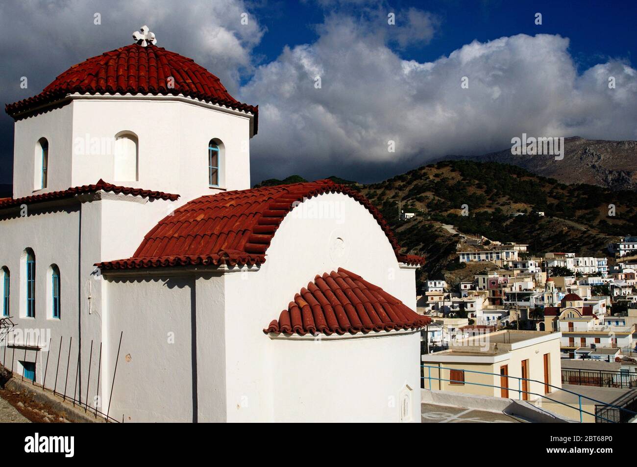 Greece, Karpathos island, Christian orthodox church with the village of Olympos in the background. Stock Photo