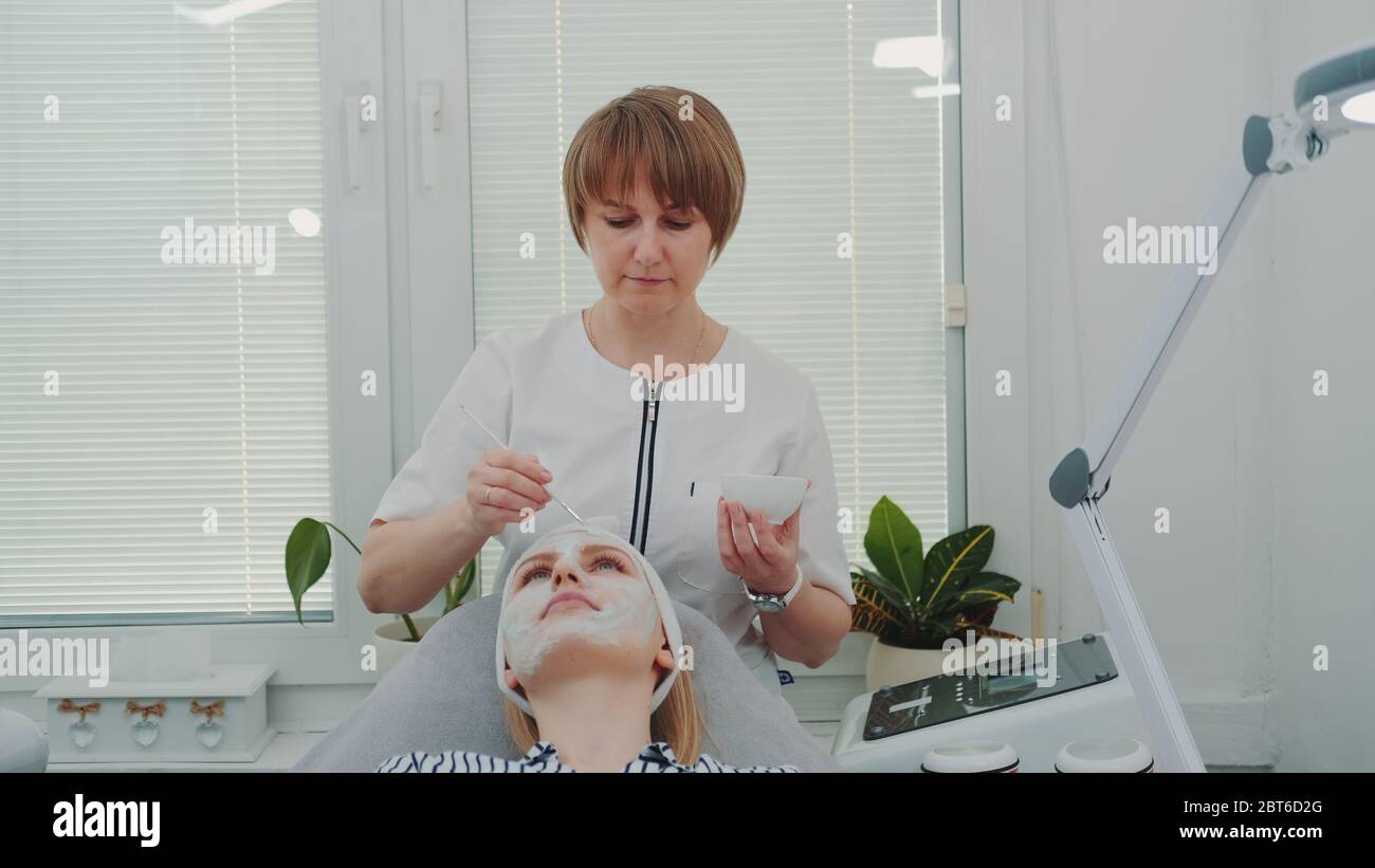 Beautician putting cream mask hi-res stock photography and images - Alamy