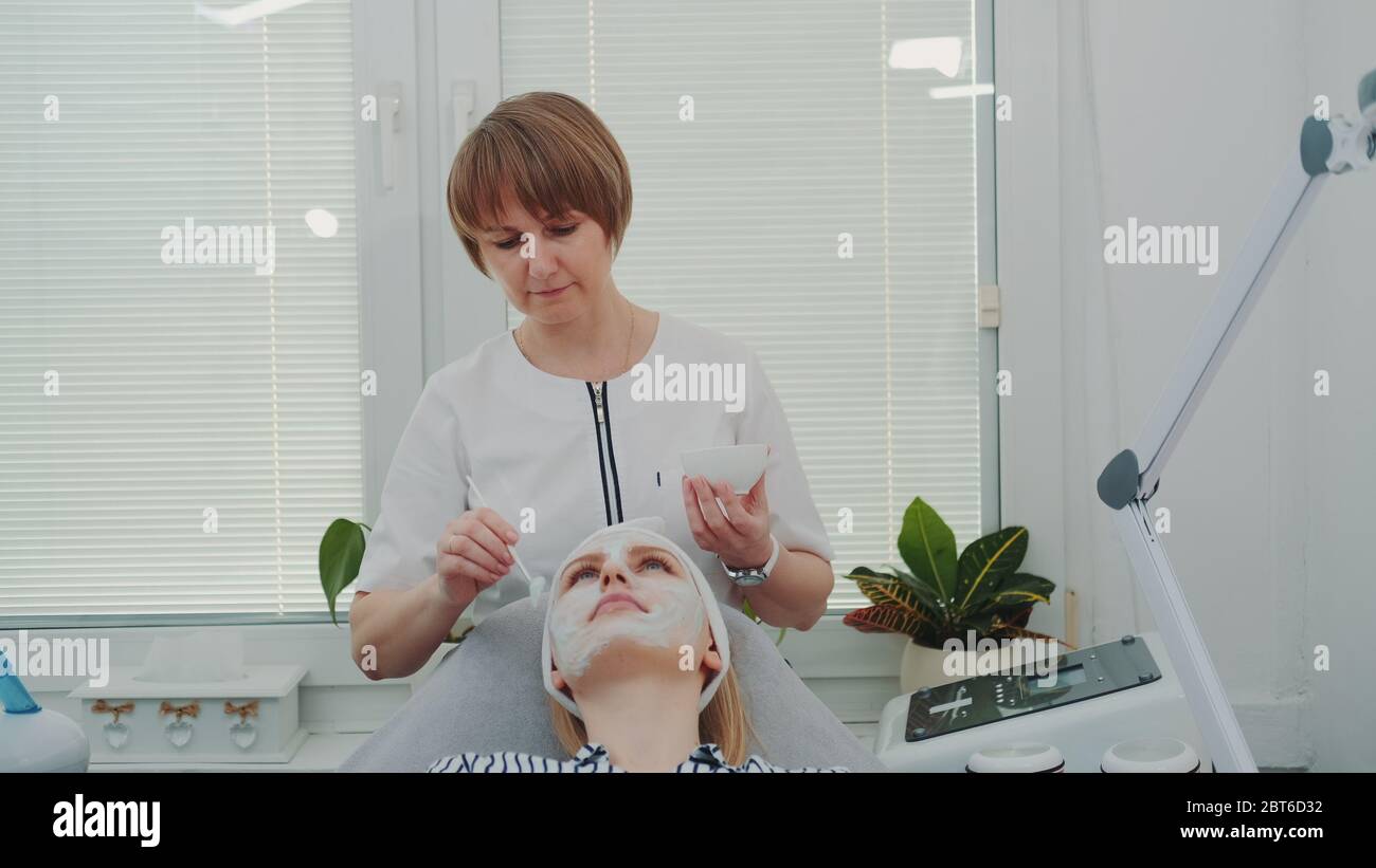 Beautician putting cream mask hi-res stock photography and images - Alamy