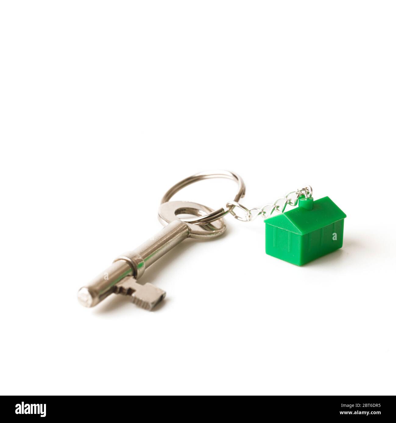 House key with green house keyring on white background Stock Photo - Alamy