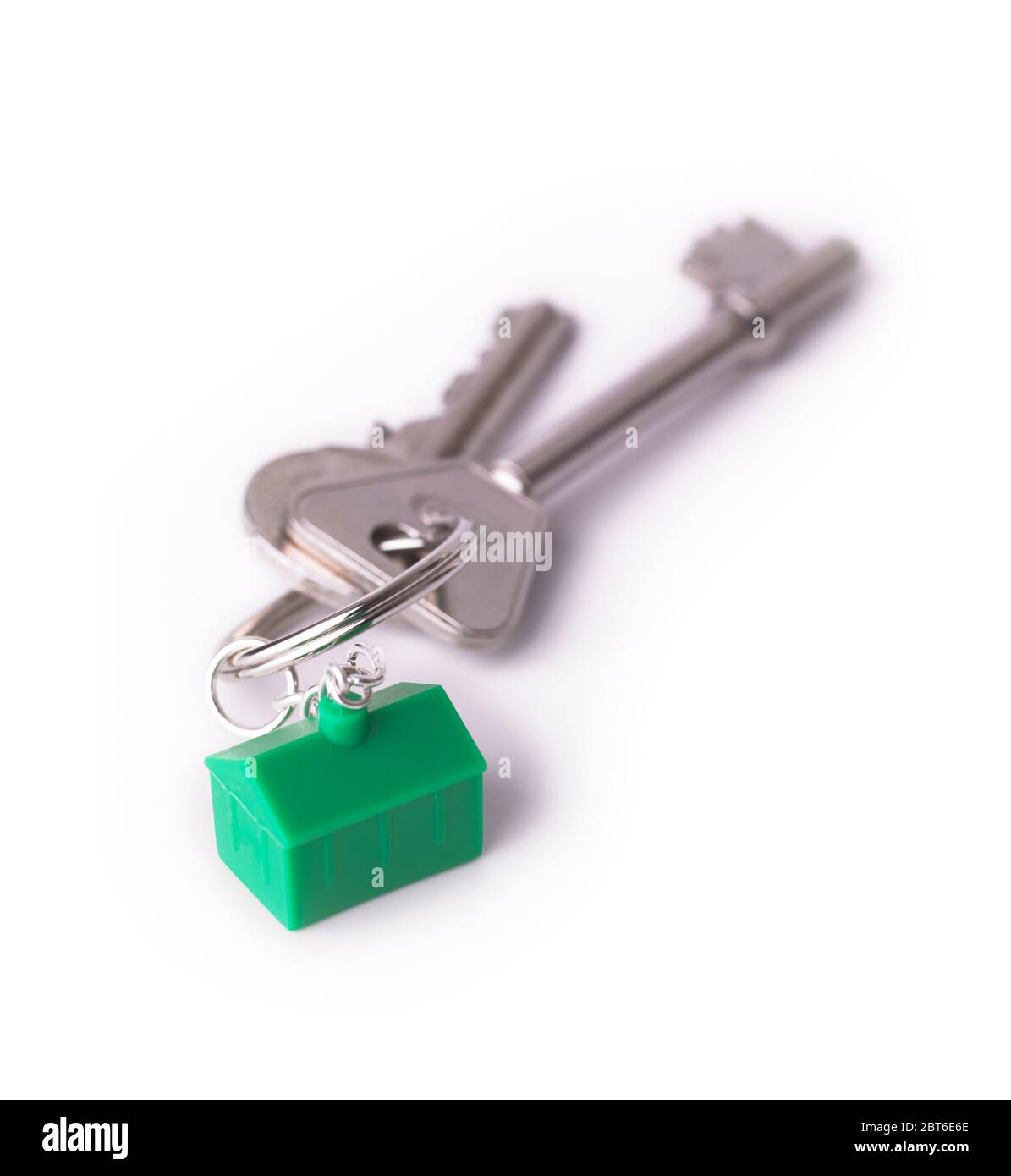 House keys with green house keyring on white background Stock Photo