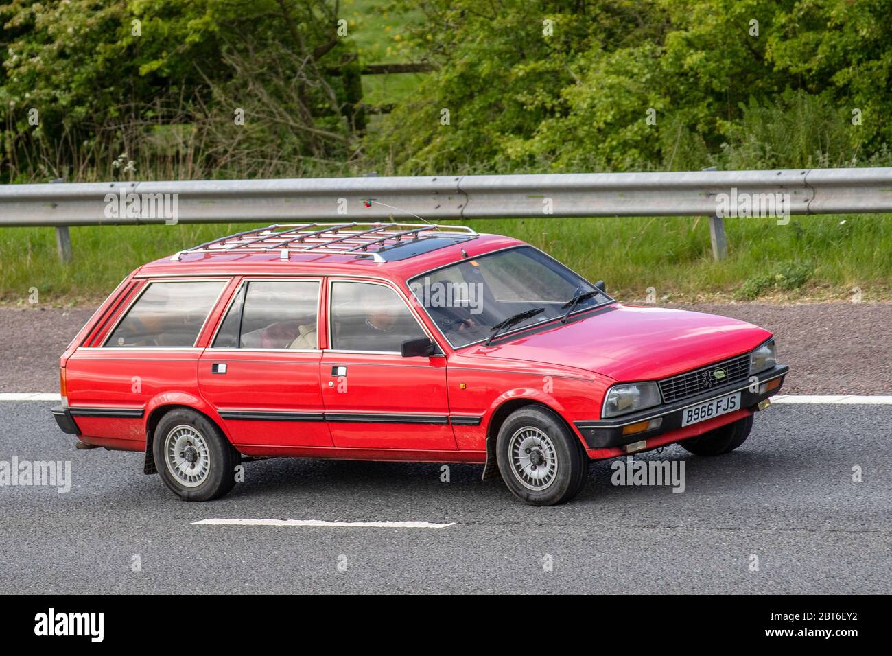 1985 80s red Peugeot 505 Family; Vehicular traffic moving vehicles, cars driving vehicle on UK roads, motors, motoring on the M61 motorway highway Stock Photo