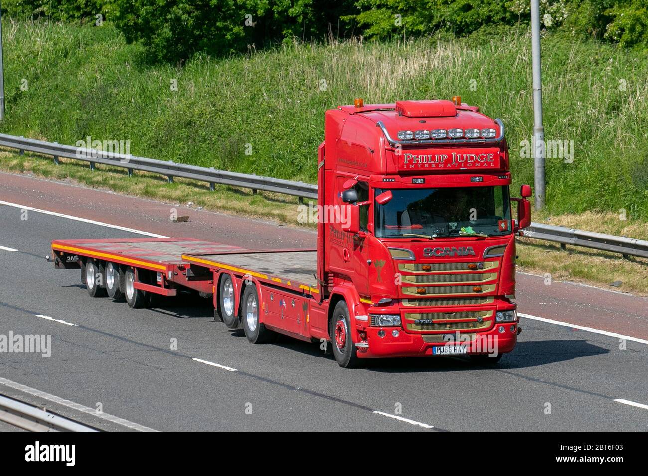 Philip Judge International; Haulage delivery trucks, lorry, transportation, truck, cargo carrier, red Scania R730 vehicle, European commercial transport, industry, M6 at Manchester, UK Stock Photo
