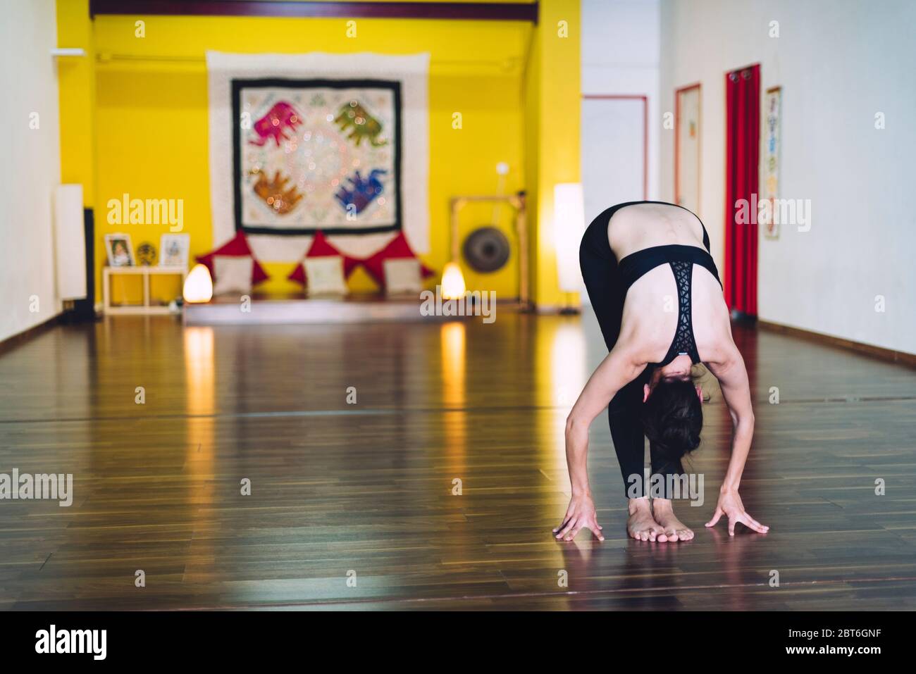 Woman doing yoga in a yoga school with her hands resting on the floor. Concept of yoga Stock Photo