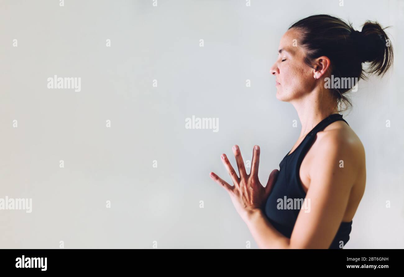 profile of a half-body woman with relaxed hands together doing yoga. copy space Stock Photo