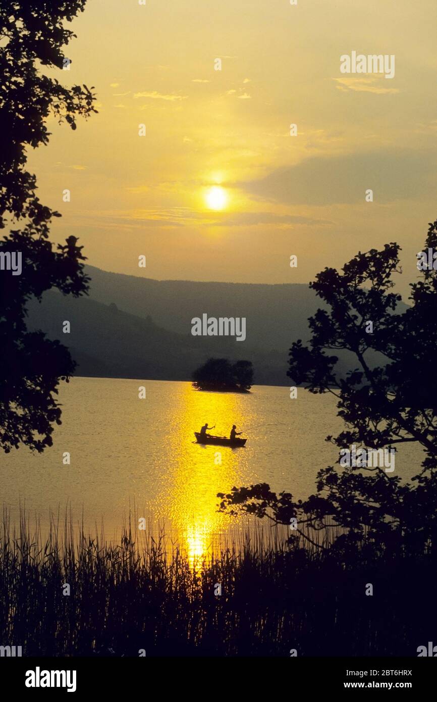 Fly fishing on Loch Kindar, New Abbey with two men in a boat at sunset