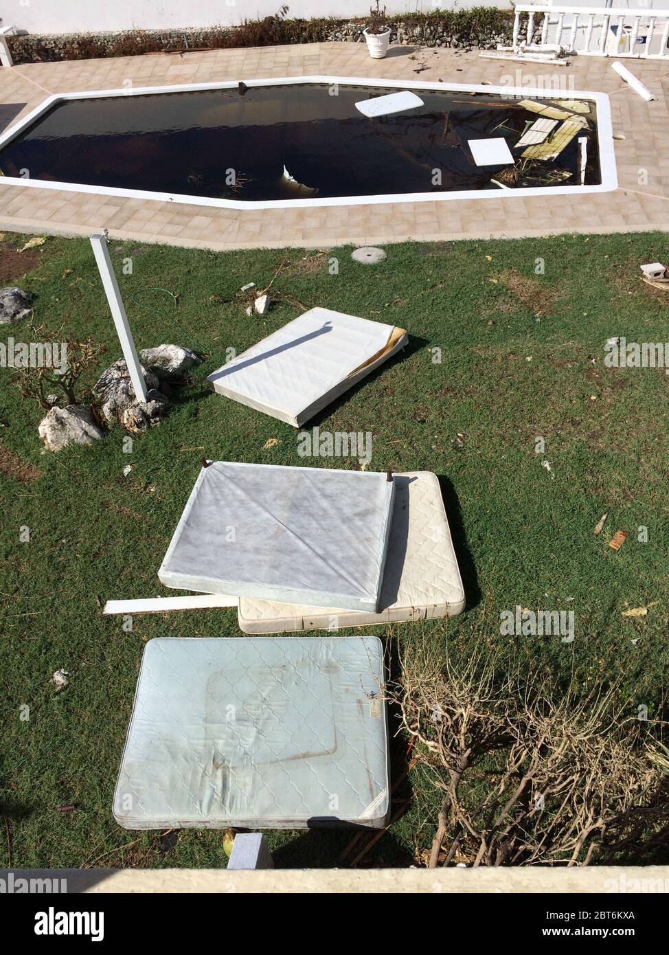 Damaged mattresses and a dirty swimming pool as household clean up starts after the passing of major Hurricane Irma on Sint Maarten in September 2017 Stock Photo