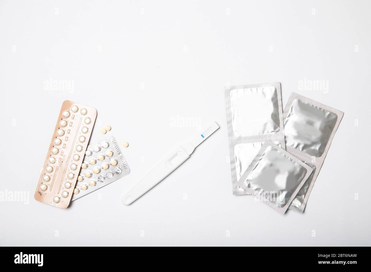 Condoms, birth control pills and pregnancy test on a white background Stock Photo