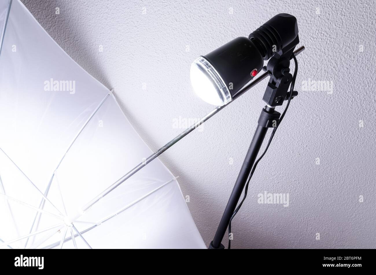Studio flash bulb with stand and soft box umbrella during action