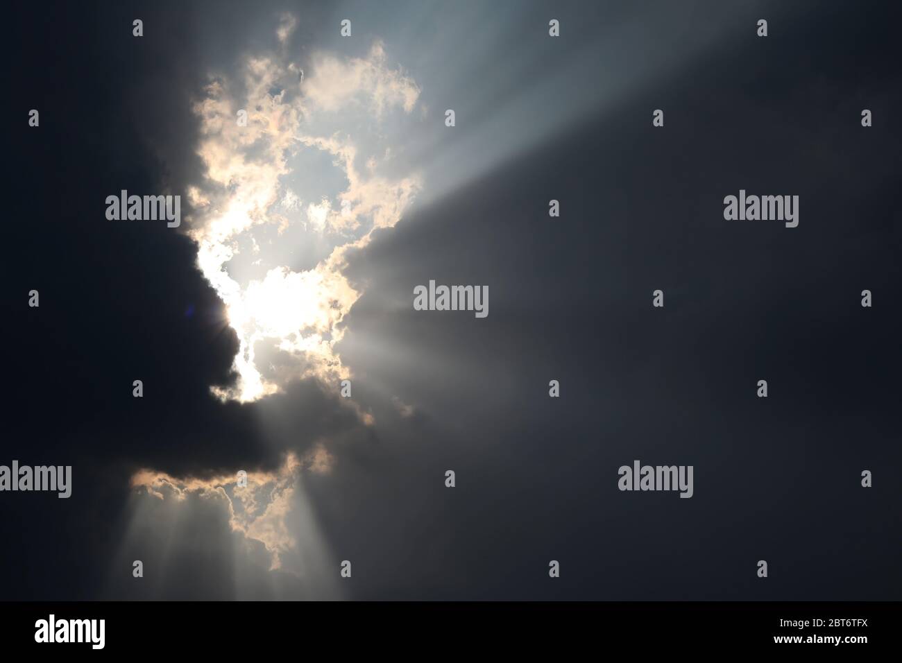 The light shone through from a dark cloud. The sun shines through the