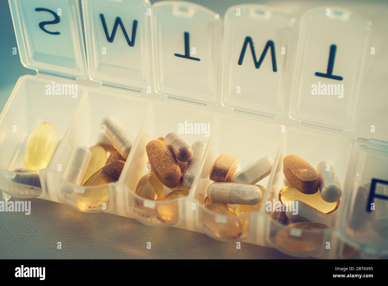https://c8.alamy.com/comp/2BT6X95/daily-pill-organizer-with-drugs-tablets-and-dietary-supplements-pill-box-with-medication-close-up-2BT6X95.jpg
