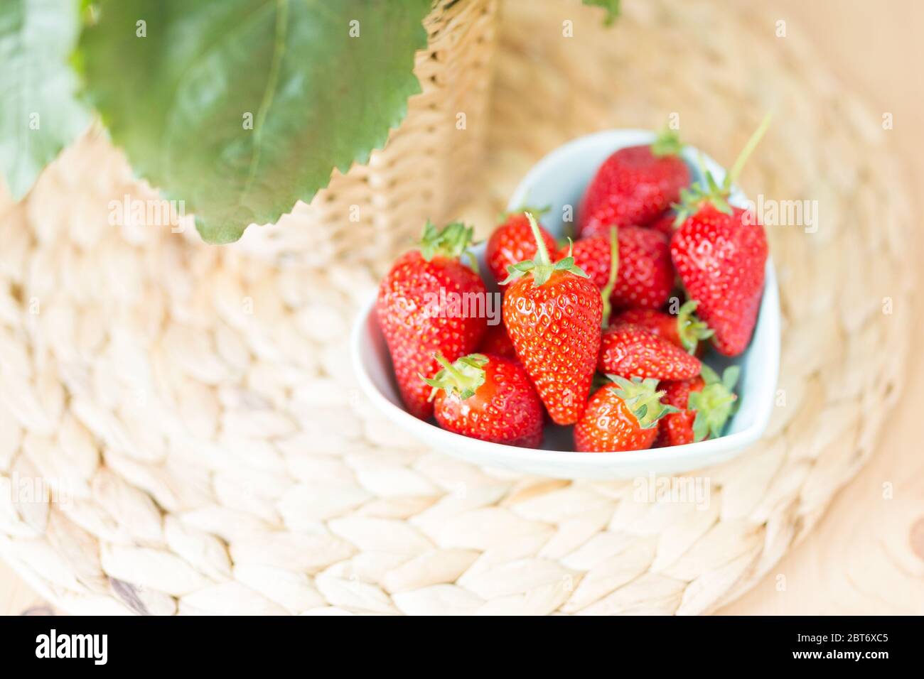 Top view close up of heart shaped Bowl of fresh strawberry on the table. Free space. Copy space. Summer concept.  Stock Photo