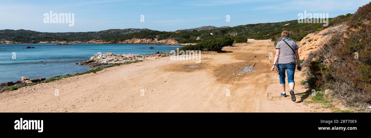 Caprera,Italy,07-april-2018:Adult womand walking along the roads of Caprera island, this island belongs to the maddalena archipel and you can reach it by bridge from maddalena Stock Photo