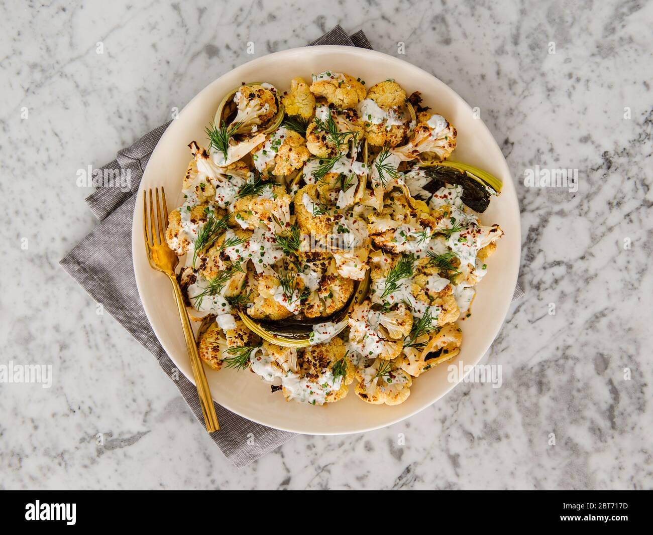 Roasted cauliflower served with tahini, Greek yogurt and spices Stock Photo