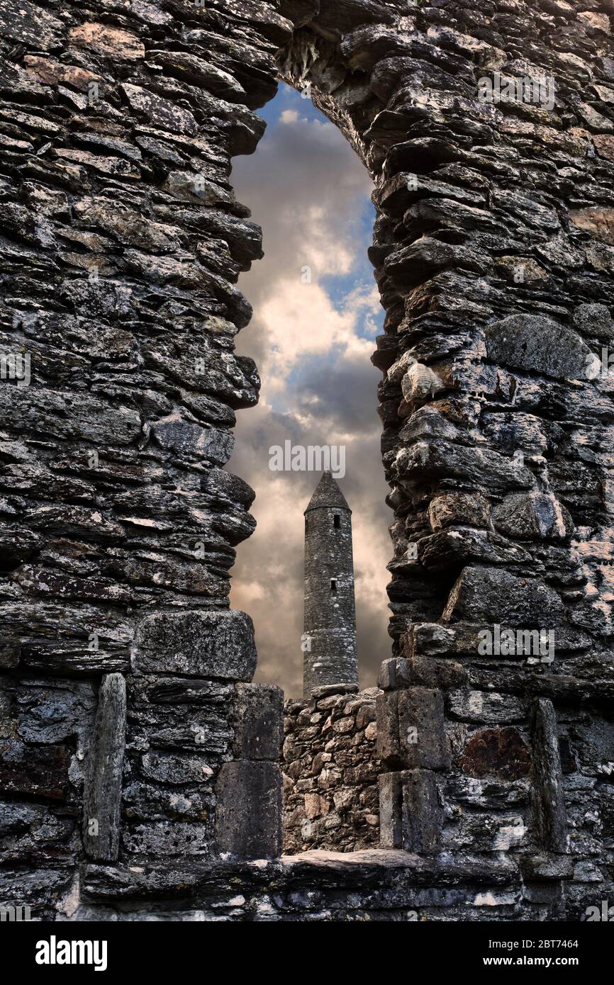 The round tower which forms part of the monastic remains at Glendalough in county Wicklow.  This early Christian ecclesiastical settlement was founded Stock Photo