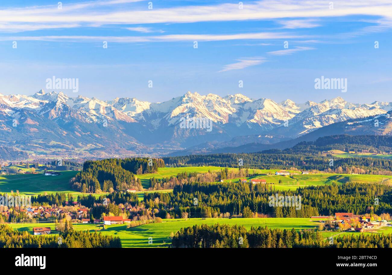 Allgäu landscape with snowy mountains and green meadows in spring. Bavaria, Germany Stock Photo