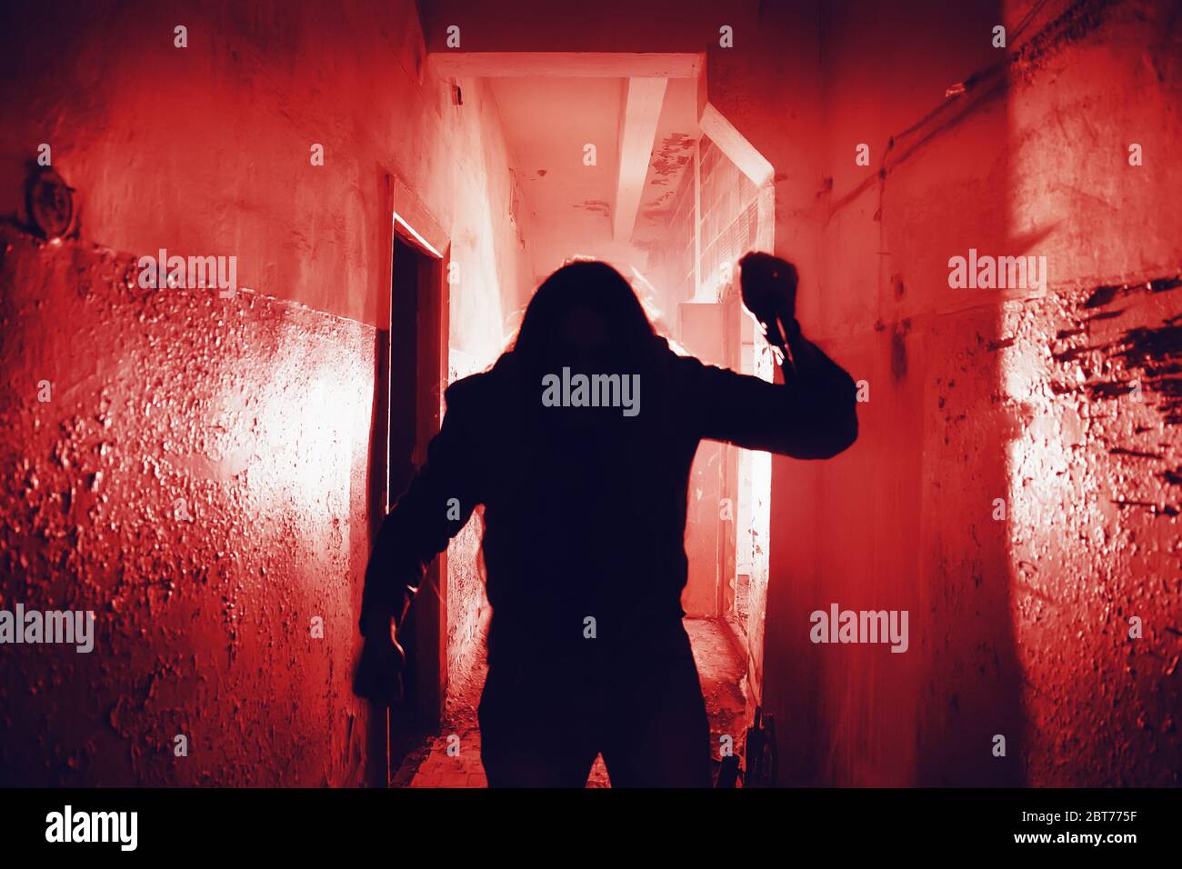 Silhouette of murderer with knife in hand. Scary thriller style in red color. Horror movie killer concept. Stock Photo