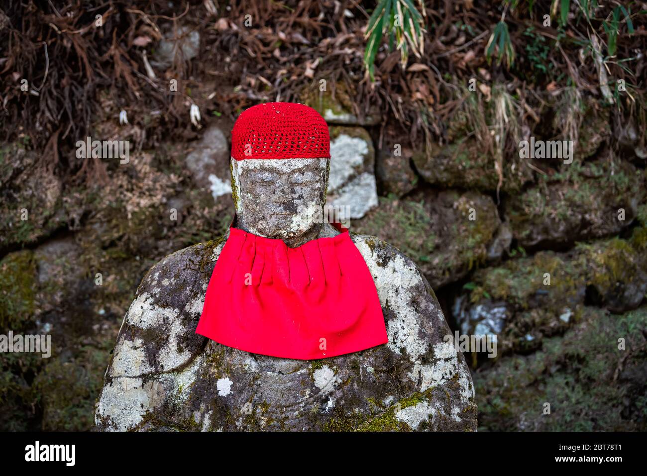 Stone rock Jizo statue in Kanmangafuchi Abyss, Nikko, Tochigi in Japan with red hat bib