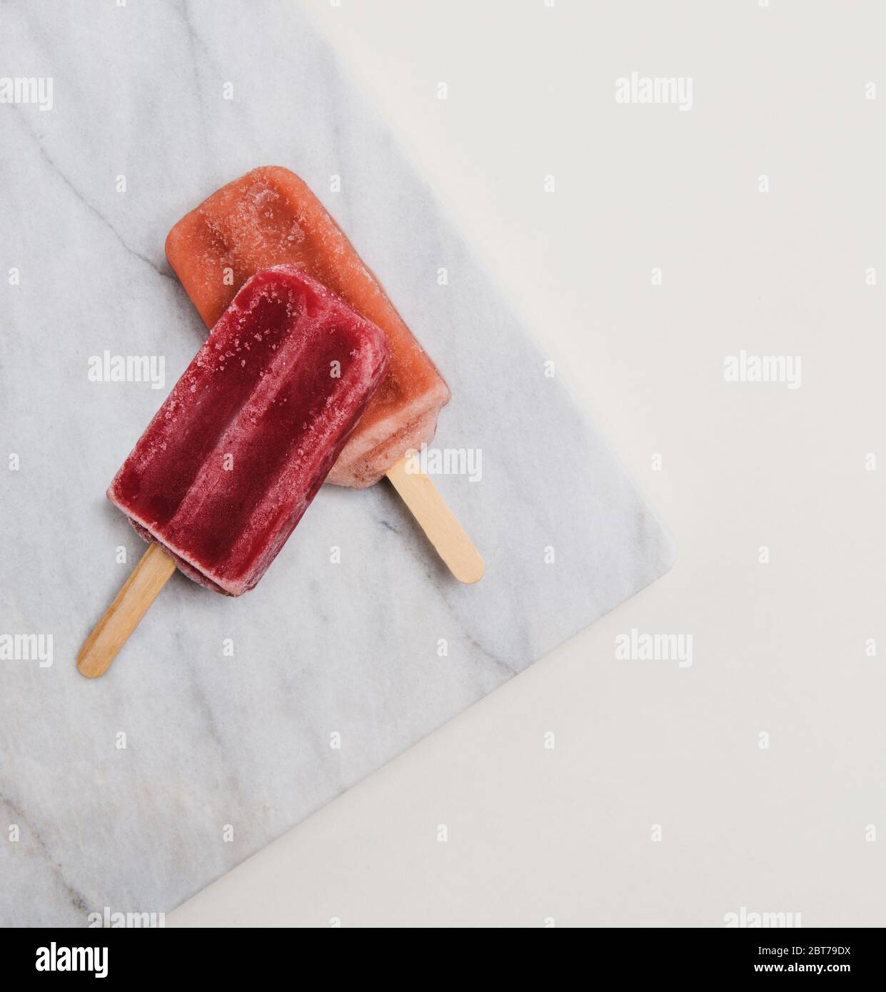 Raspberry and Strawberry popsicles on marble Stock Photo