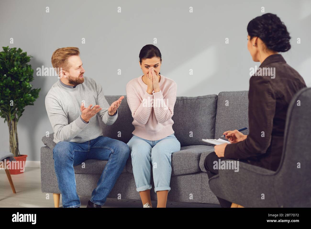 Psychologist at a psychotherapy session with a couple in the room. Man and woman visit a psychologist in an office. Stock Photo