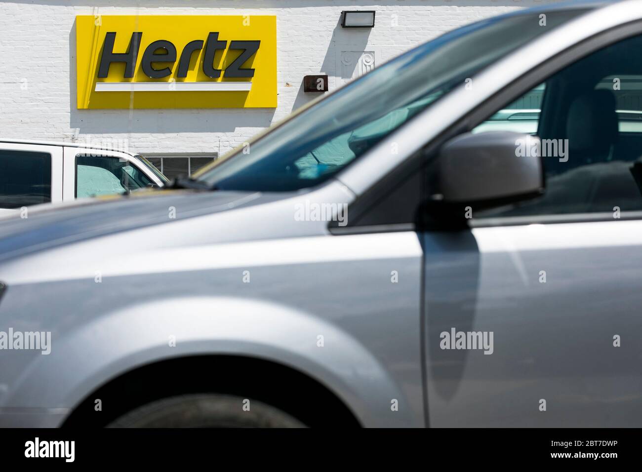A logo sign outside of a Hertz car rental location in Silver Spring, Maryland on May 23, 2020. Stock Photo