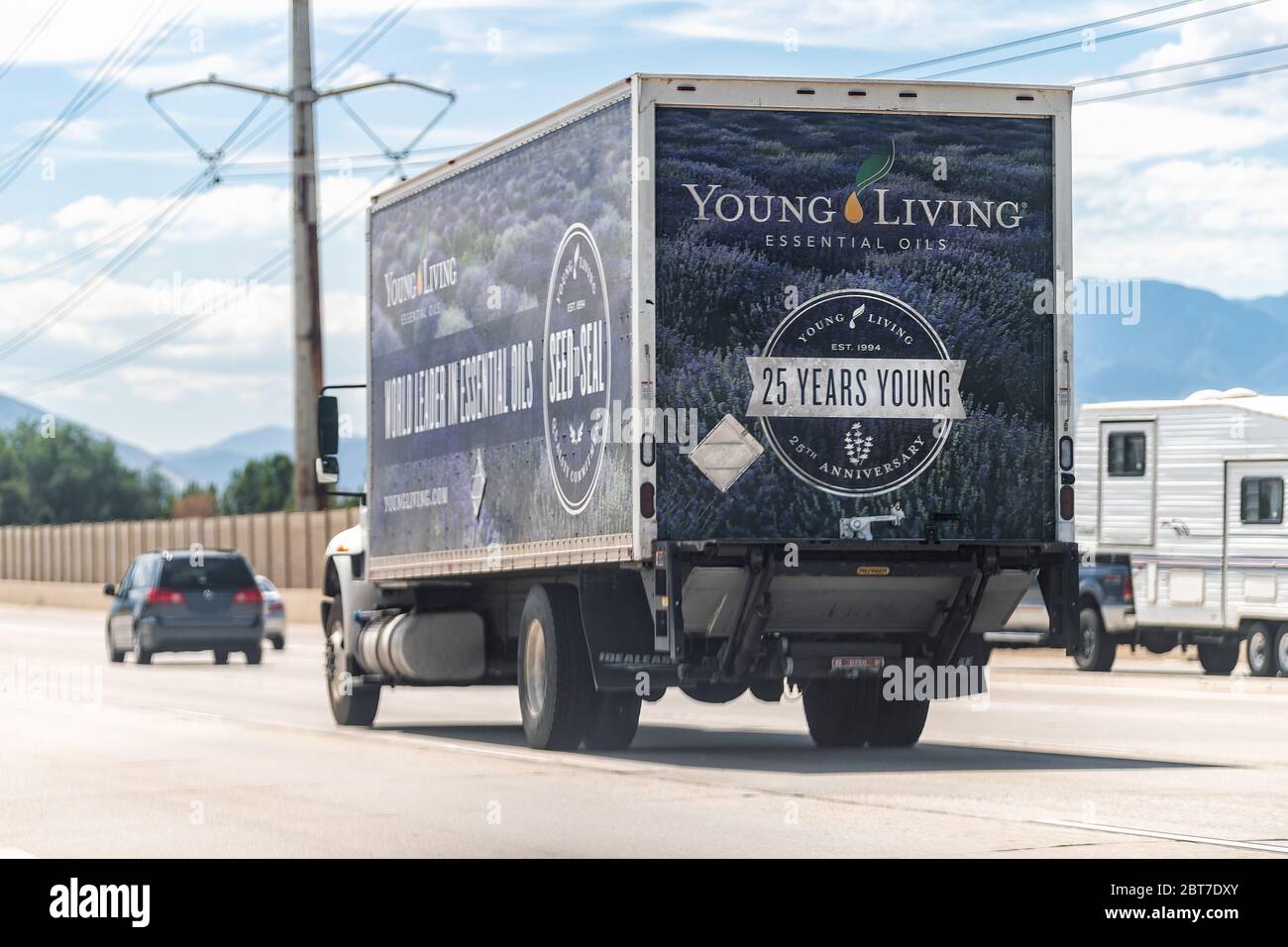 American Fork, USA - July 29, 2019: Young Living Essential Oils business company delivery truck sign near warehouse on highway road in Utah cars in tr Stock Photo