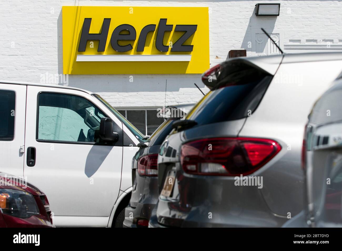 A logo sign outside of a Hertz car rental location in Silver Spring, Maryland on May 23, 2020. Stock Photo