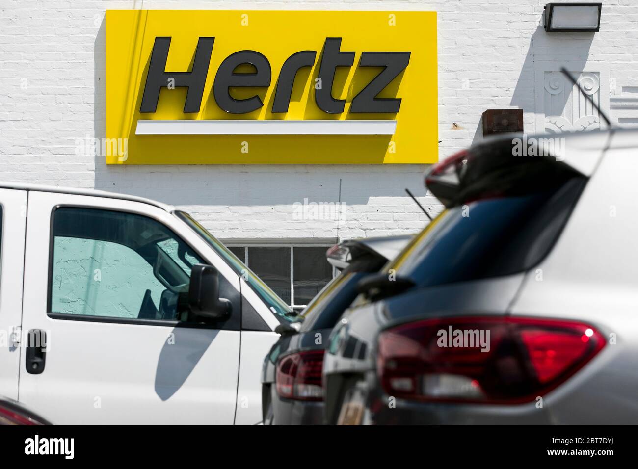 A logo sign outside of a Hertz car rental location in Silver Spring, Maryland on May 23, 2020. Stock Photo