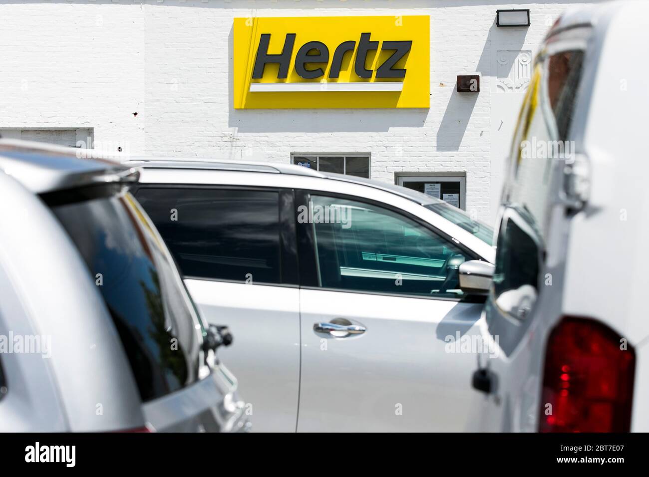 A logo sign outside of a Hertz car rental location in Silver Spring, Maryland on May 23, 2020. Stock Photo