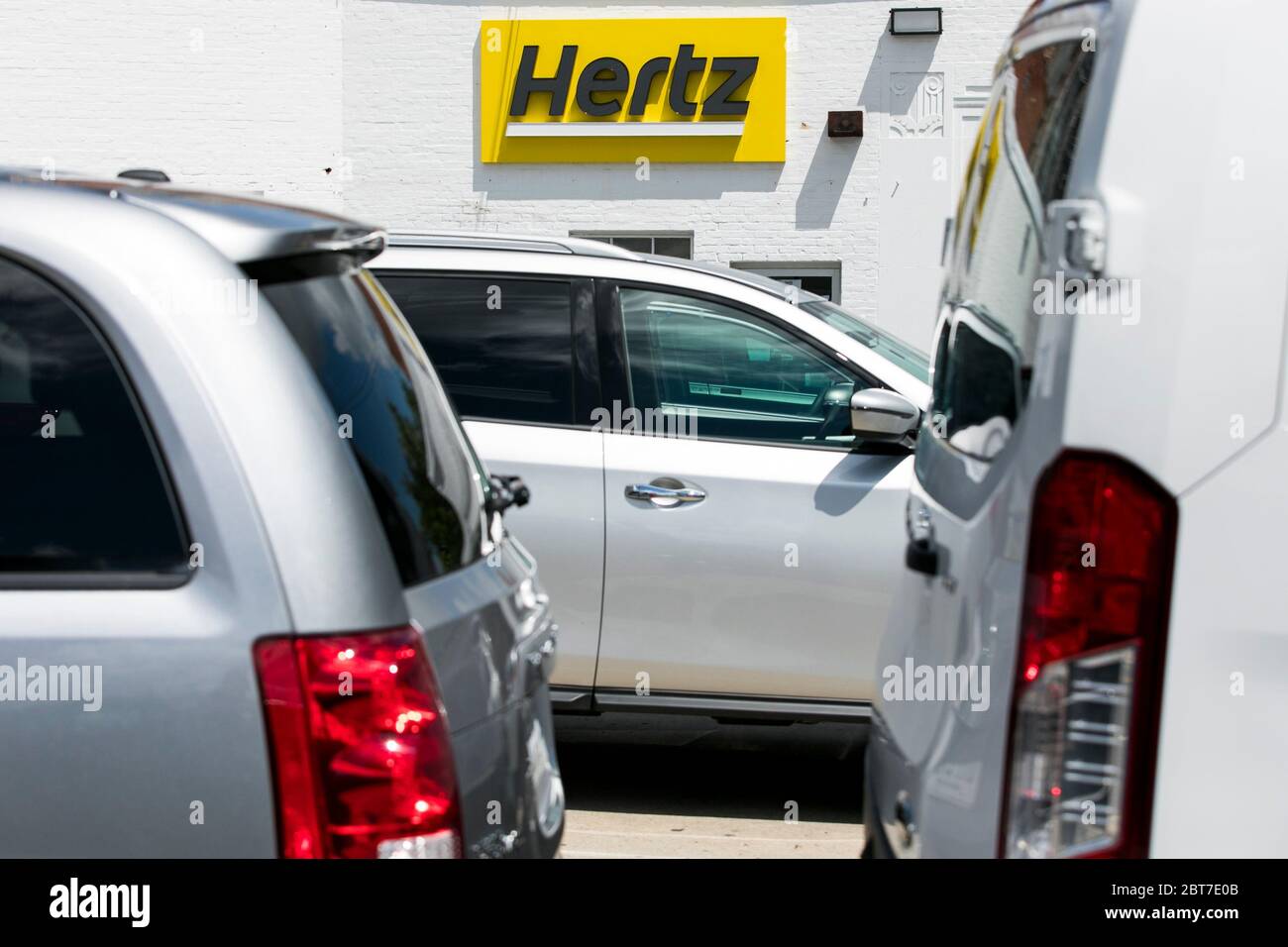 A logo sign outside of a Hertz car rental location in Silver Spring, Maryland on May 23, 2020. Stock Photo