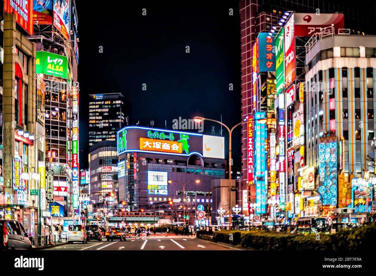 Tokyo, Japan - April 3, 2019: Yasukuni-dori avenue with cars people by Kabukicho alley street in downtown city with neon night lights cityscape Stock Photo