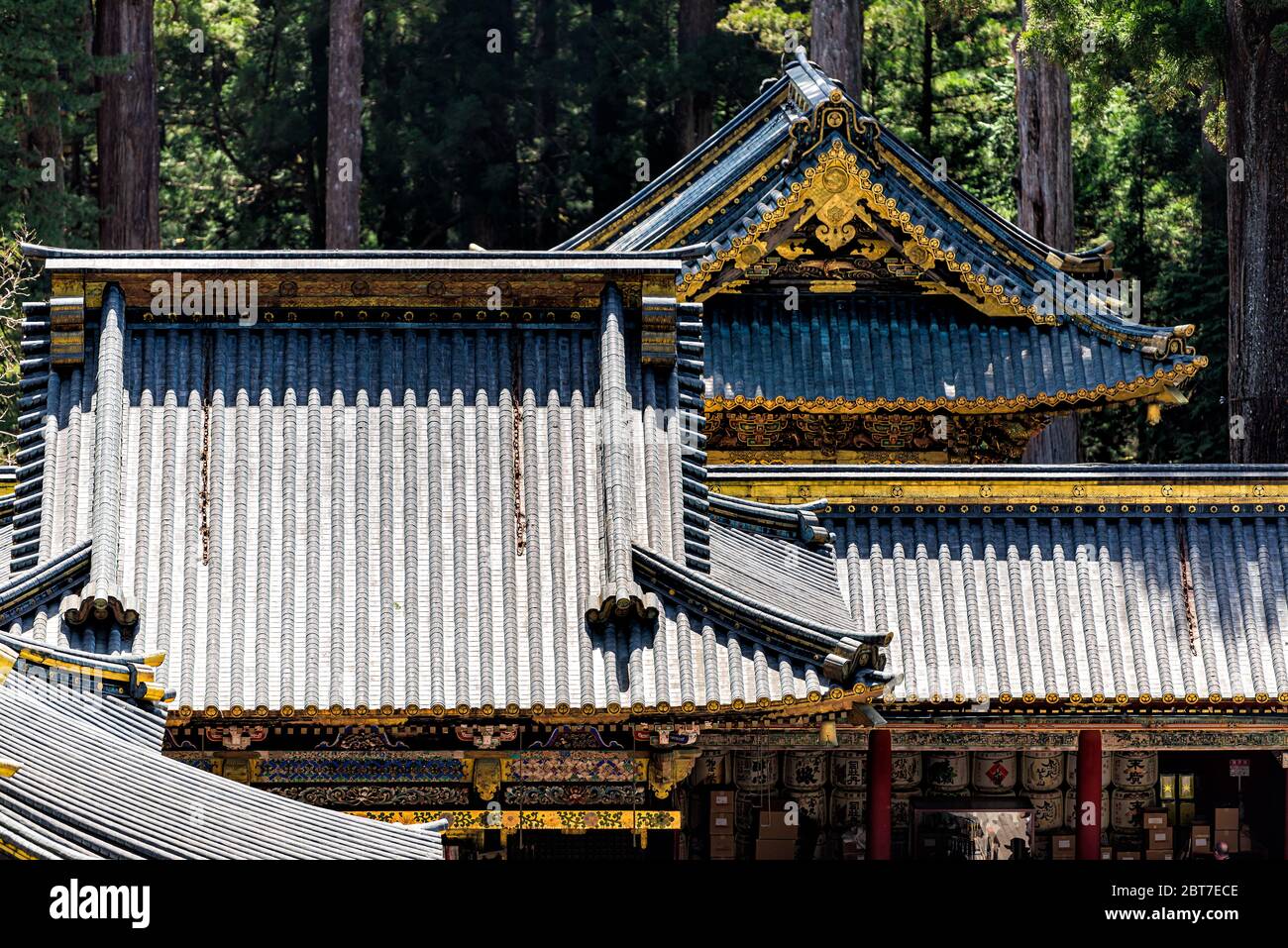 Nikko, Japan - April 5, 2019: Toshogu temple shrine roof architecture abstract view in Tochigi prefecture during spring and trees in forest Stock Photo