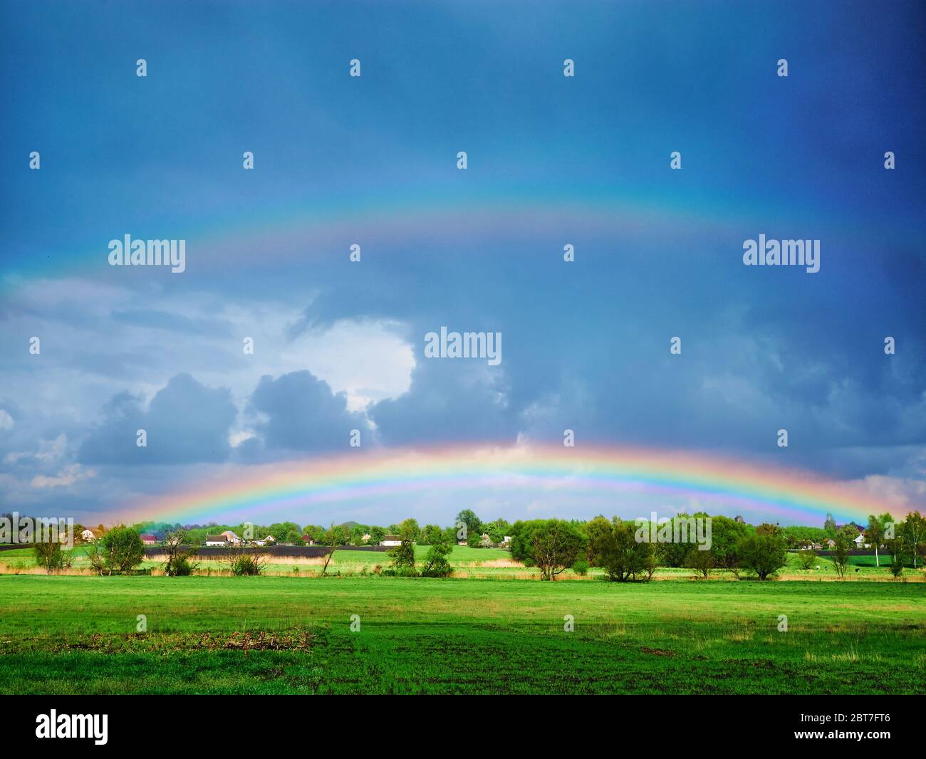 double rainbow after a thunderstorm over a green field Stock Photo - Alamy