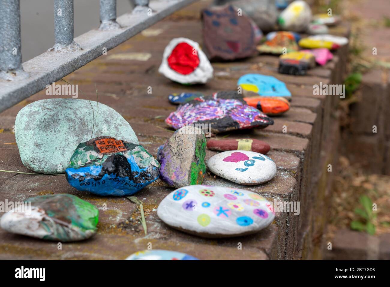 Painted stones on a wall in Duisburg-Orsoy, so called Corona stones, stone snakes, which mostly children paint and put together to a row, action again Stock Photo