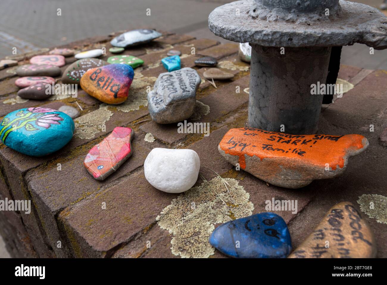 Painted stones on a wall in Duisburg-Orsoy, so called Corona stones, stone snakes, which mostly children paint and put together to a row, action again Stock Photo
