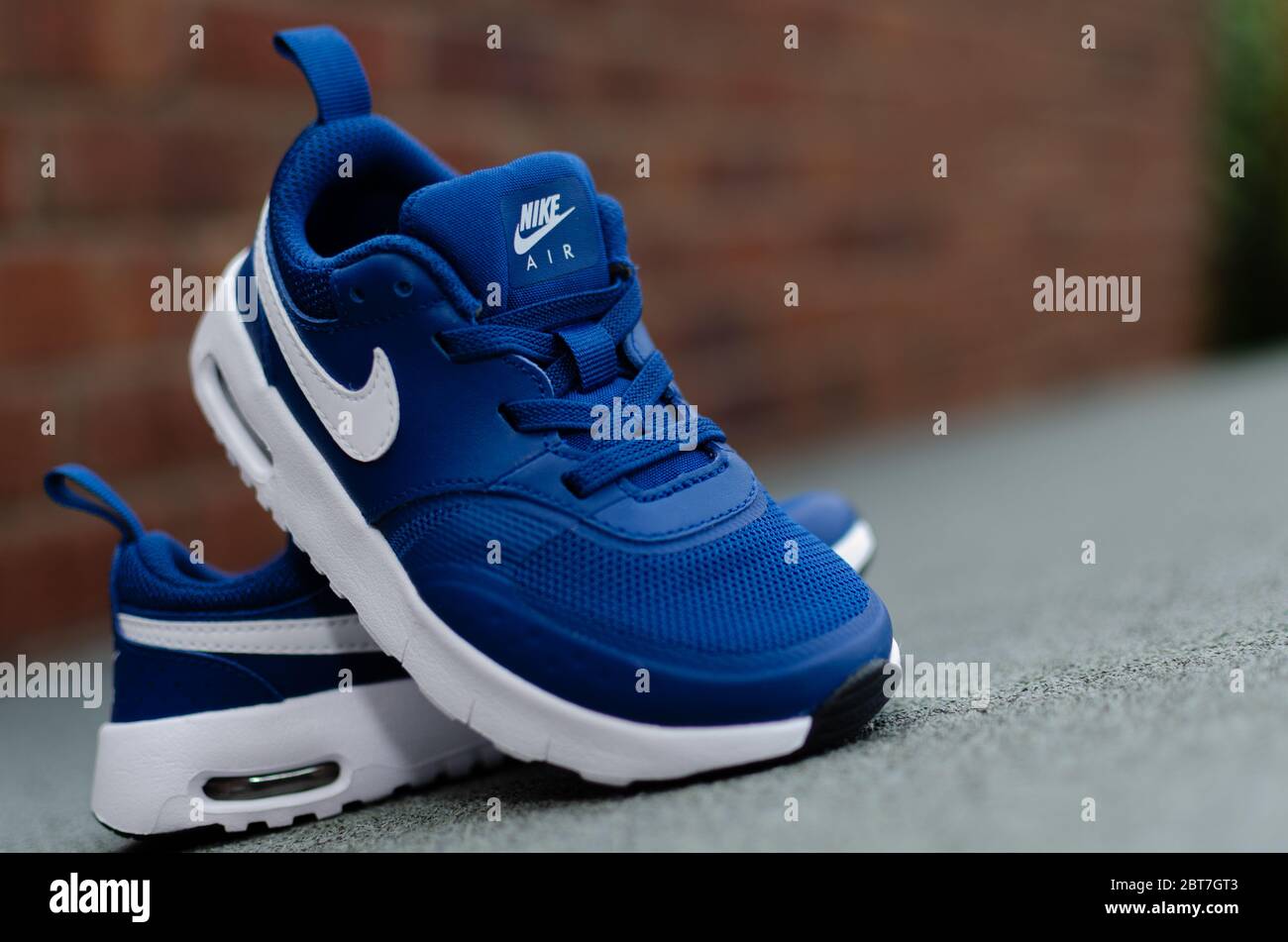 The close up photo of child's pair of blue Nike Air trainers. The brick  wall is on the background. Shallow field of view was used for imaging Stock  Photo - Alamy